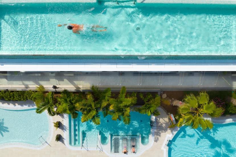 Bird-eye view of a person swimming in a rooftop pool