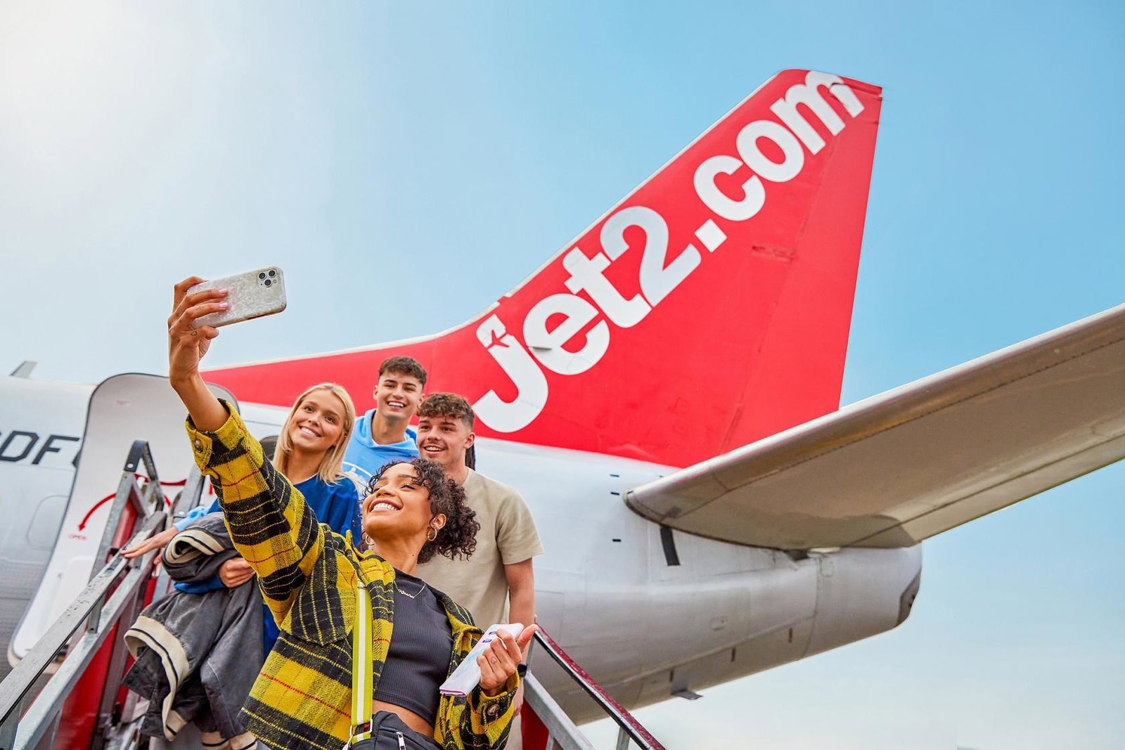 Young Jet2 customers take a selfie as they board one of the airline and operator's aircraft