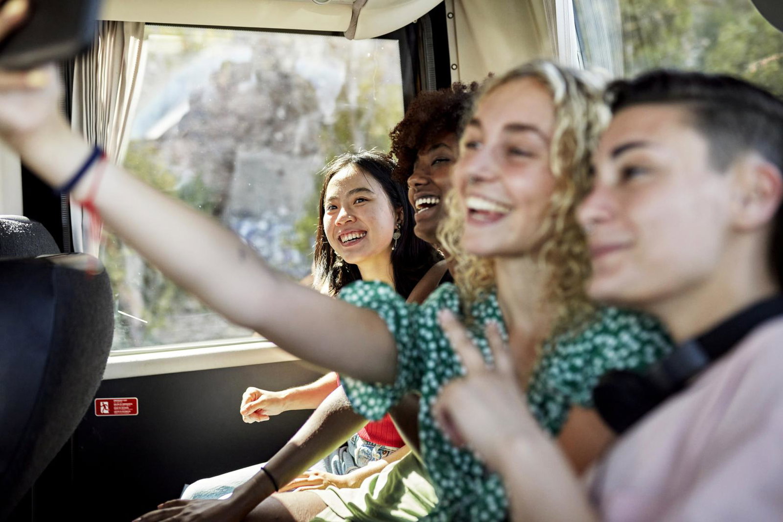 Young people taking a selfie while travelling on a coach