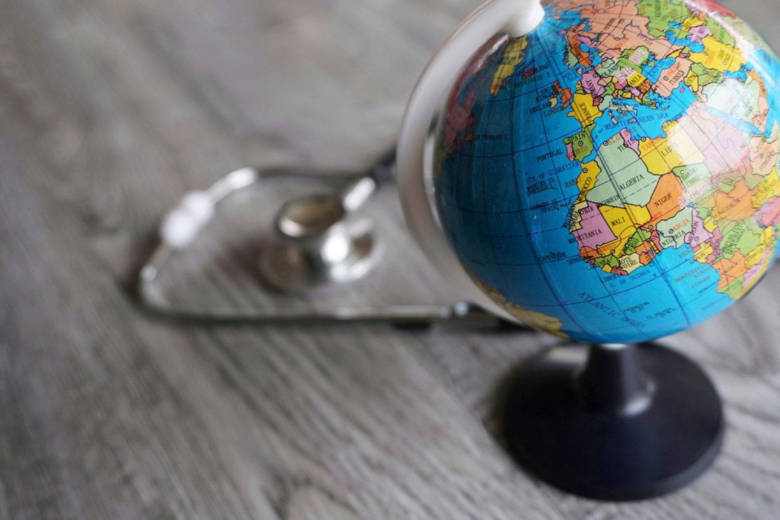 A stethoscope pictured next to a globe