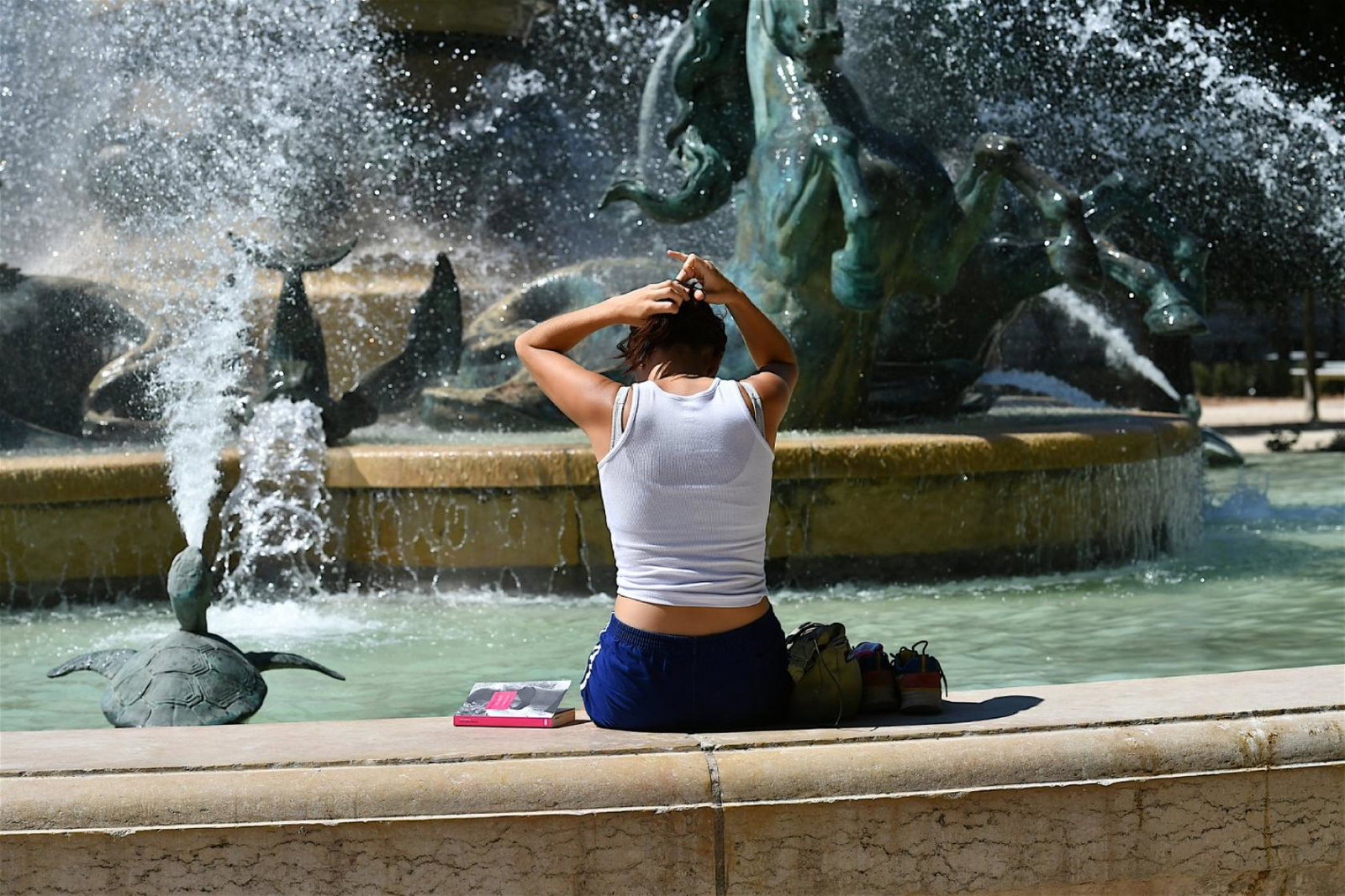 A woman cools off in a Parisian fountain