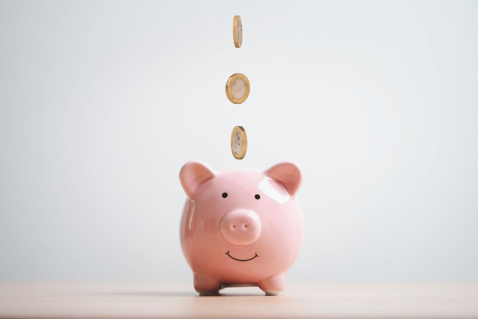 Coins falling into a piggy bank