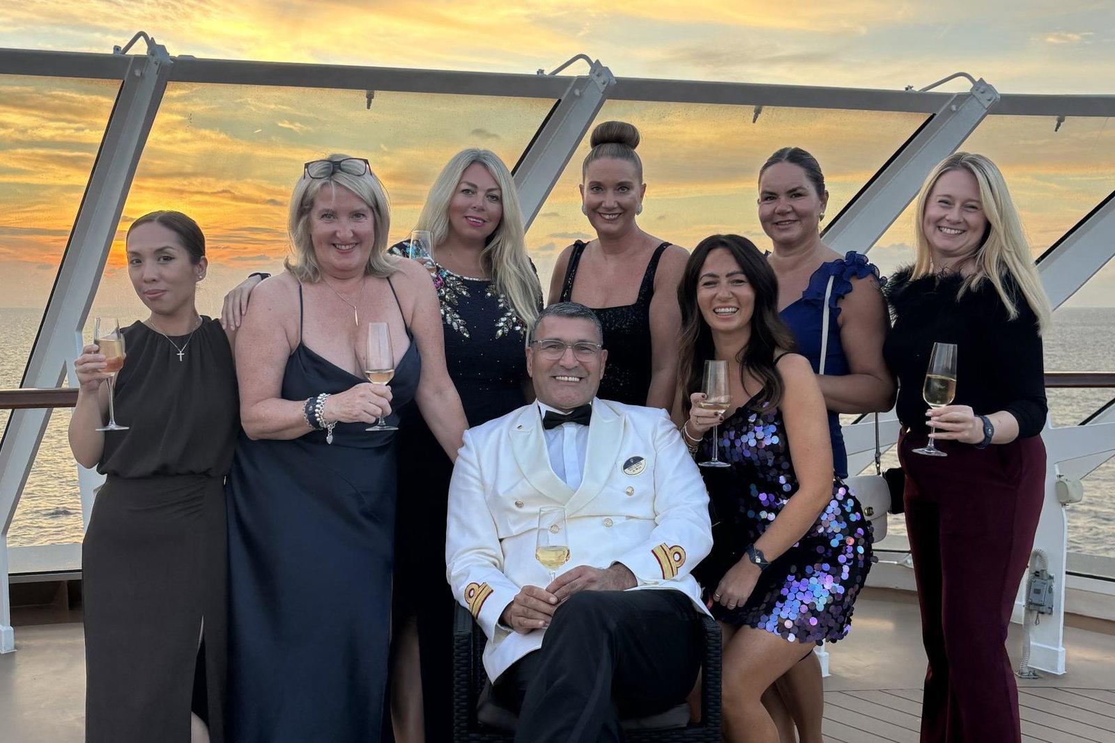 Travel agents stand behind MSC Yacht Club director with sunset in background