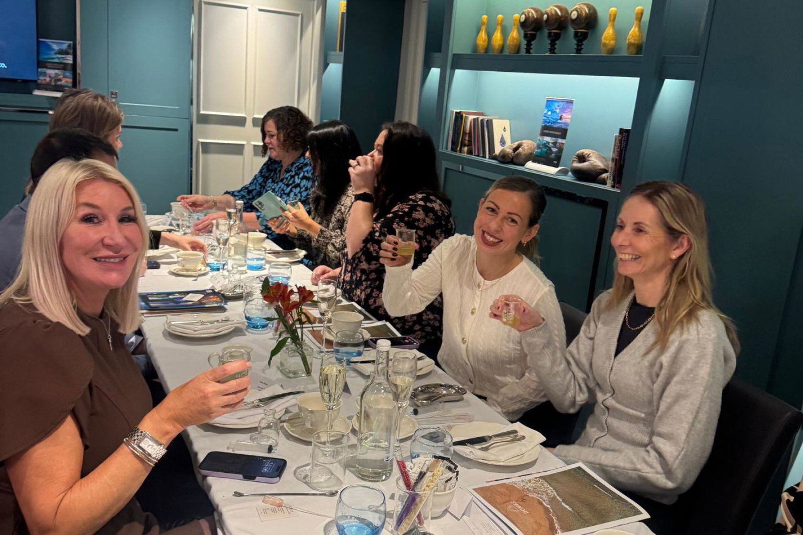 Women sitting at table smiling and drinking