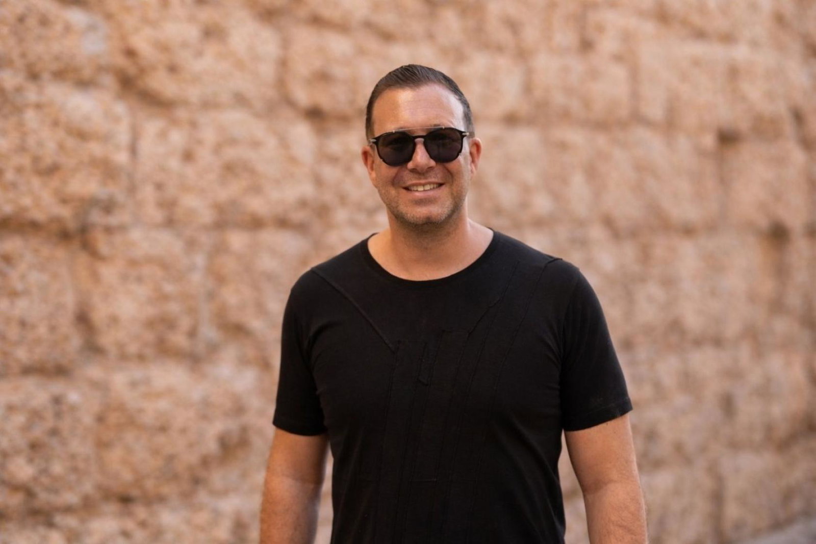 Smiling man in black t-shirt and black sunglasses 