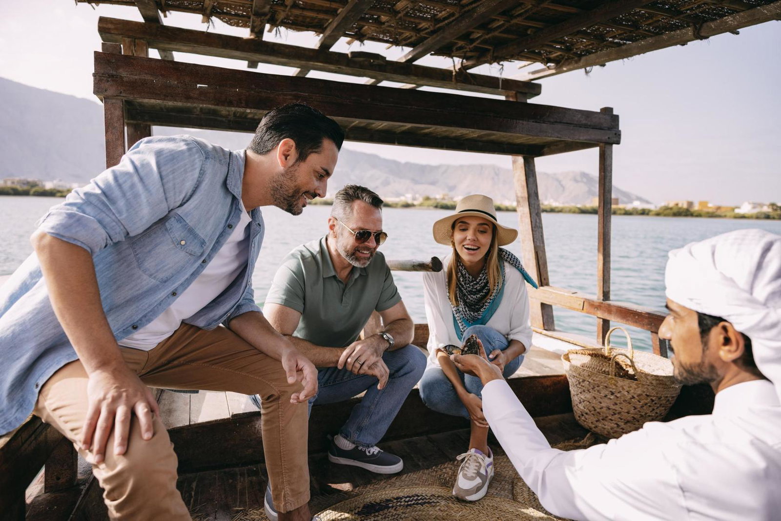 Three people looking surprised to see a pearl inside an oyster 