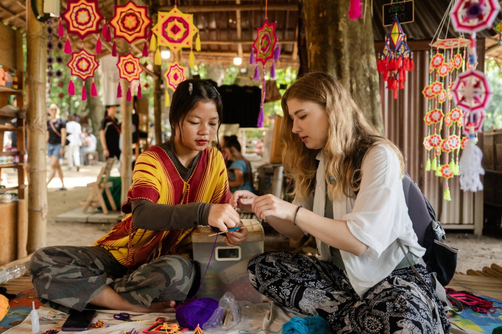 A tourist takes part in a craft workshop with a local guide