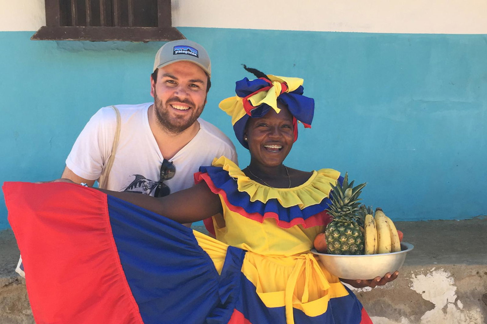 Charlie Thomas stands next to a Afro-Colombian woman wearing vibrant clothing