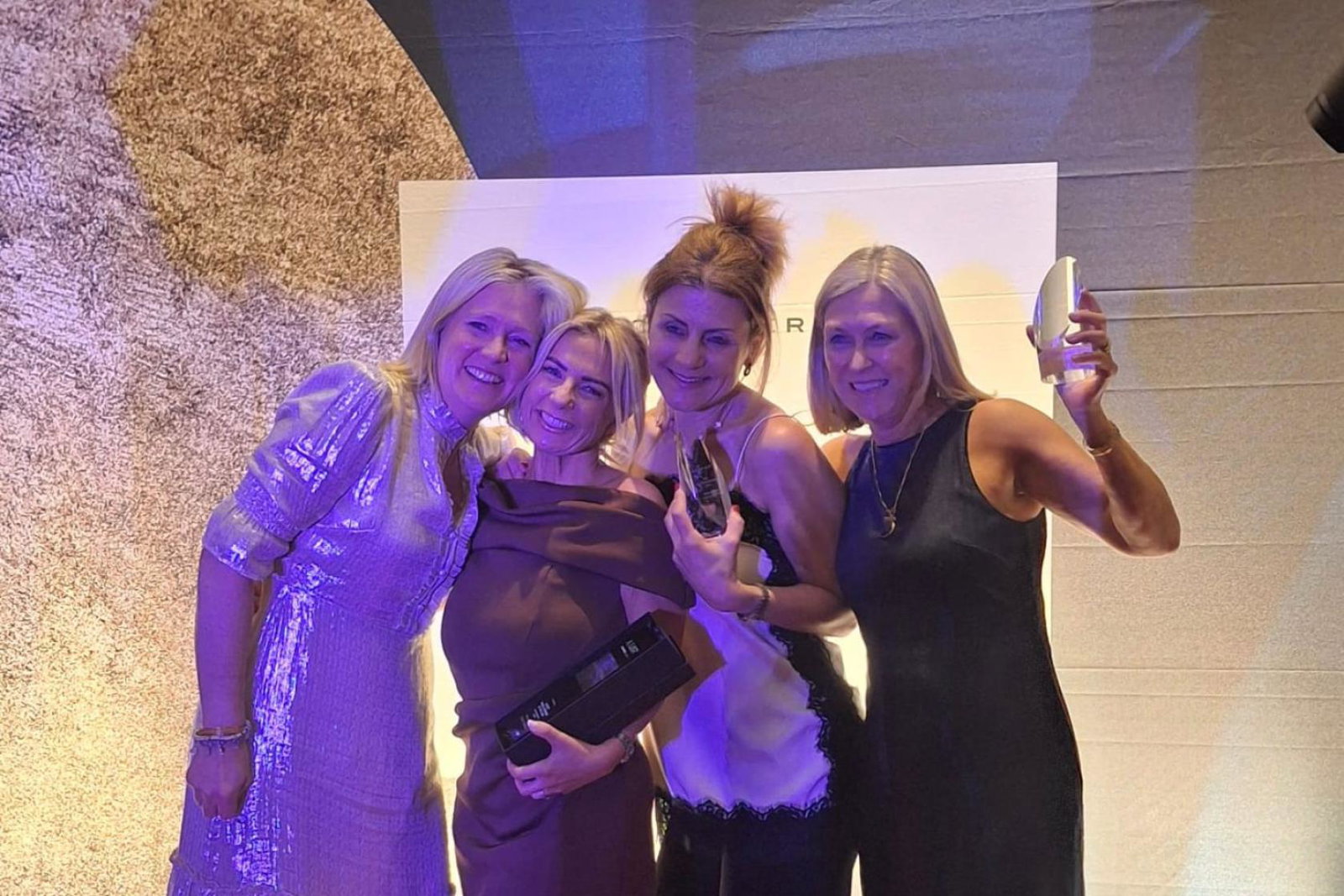 Four smiling women at an awards show 