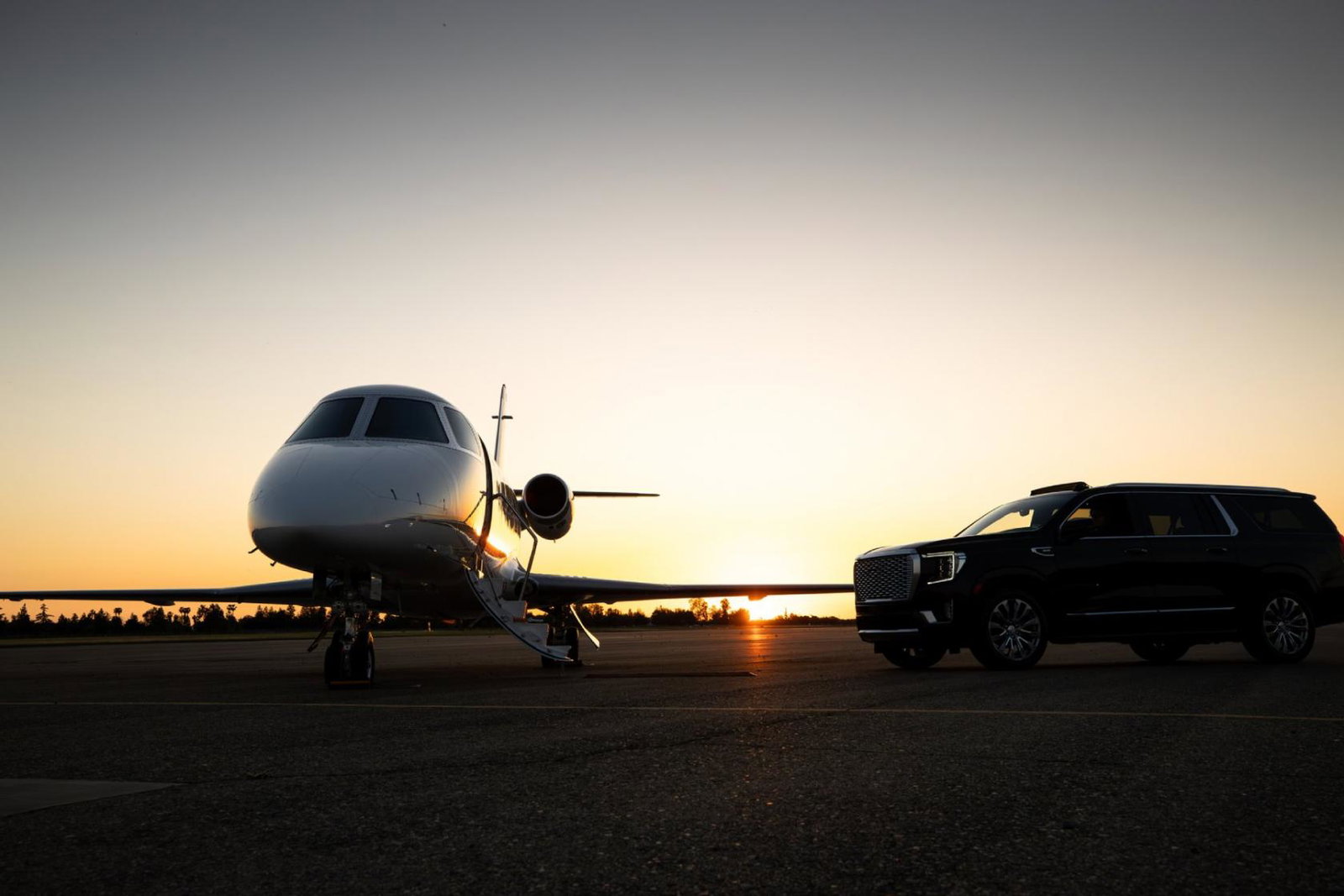 A private jet sitting on a runway at dusk
