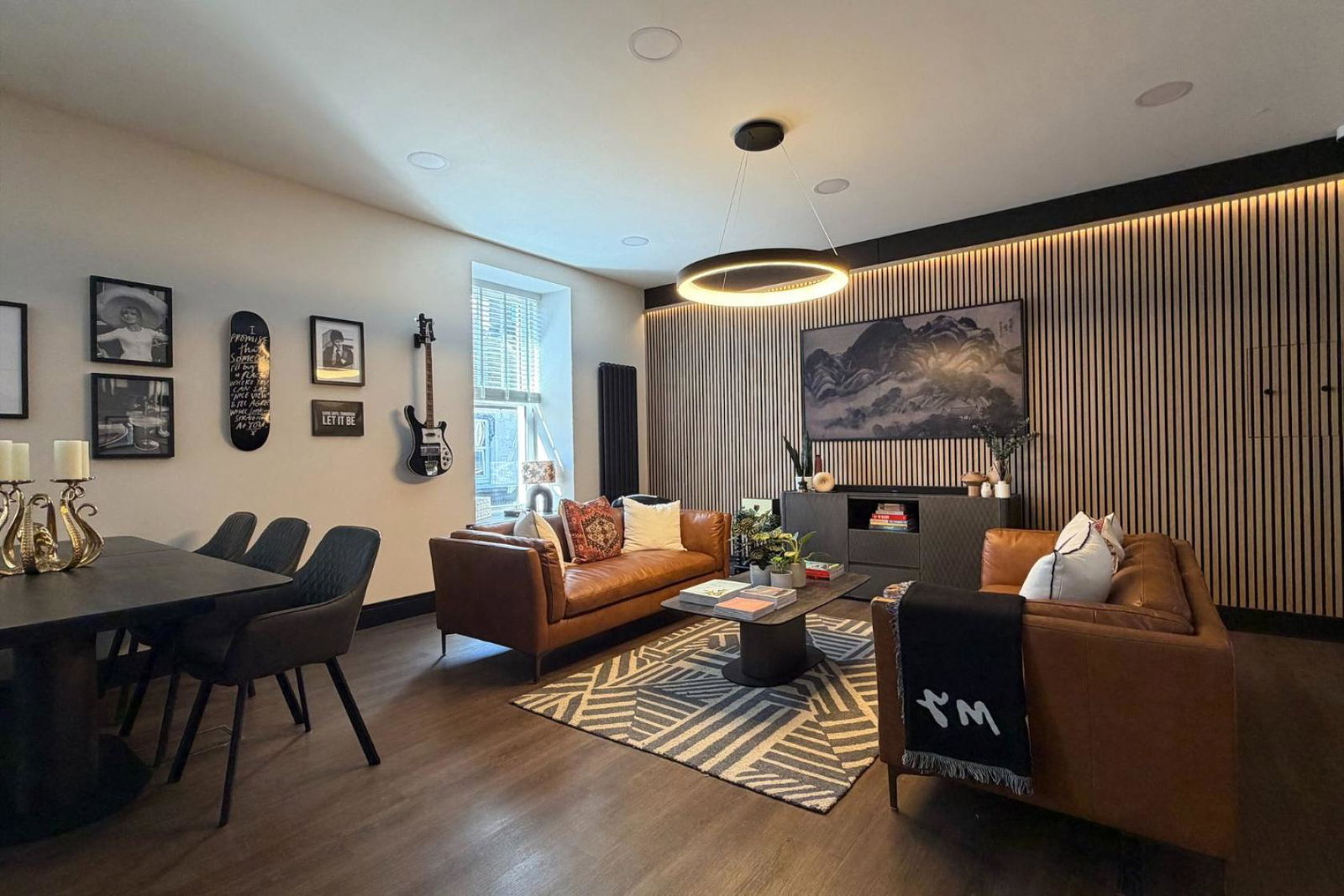 Cozy sitting room with brown couches and wooden dining set 