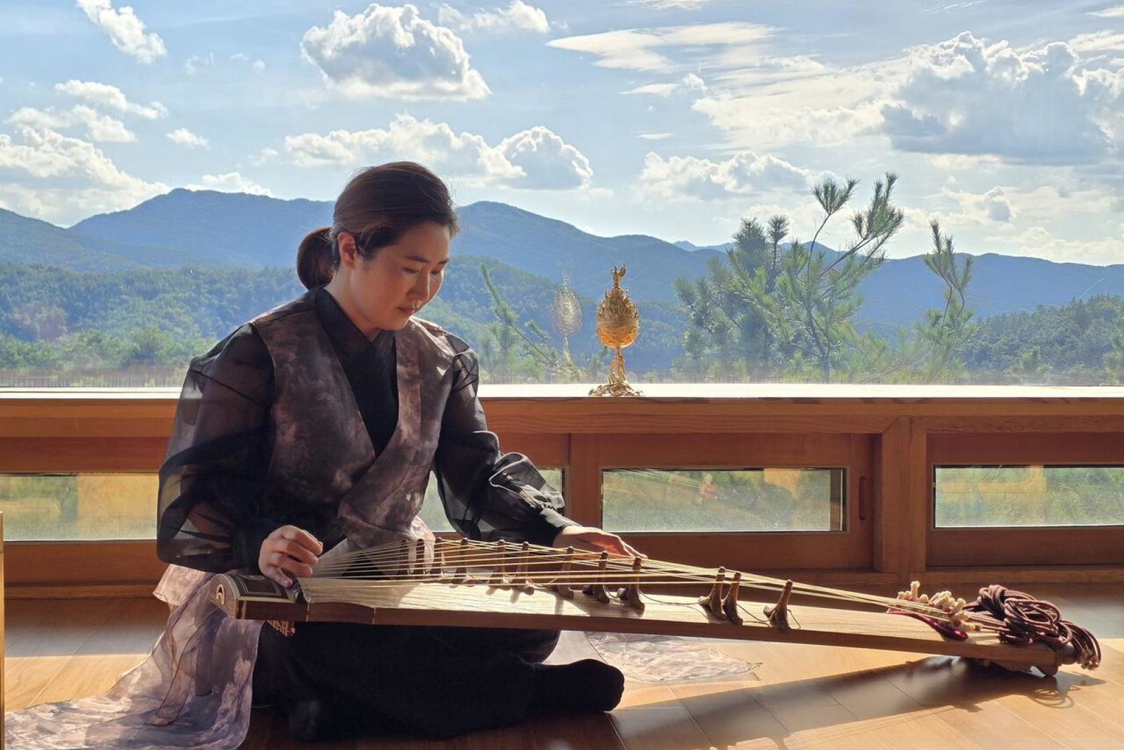 A lady plays a gayageum – a traditional Korean stringed instrument