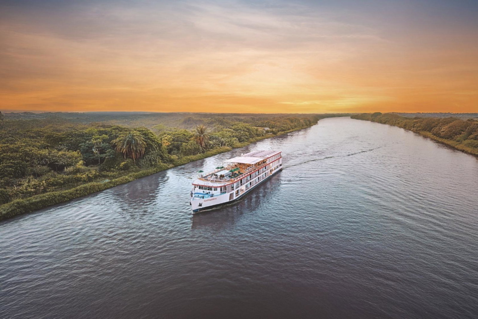 River cruise boat sails down Magdalena river during sunset