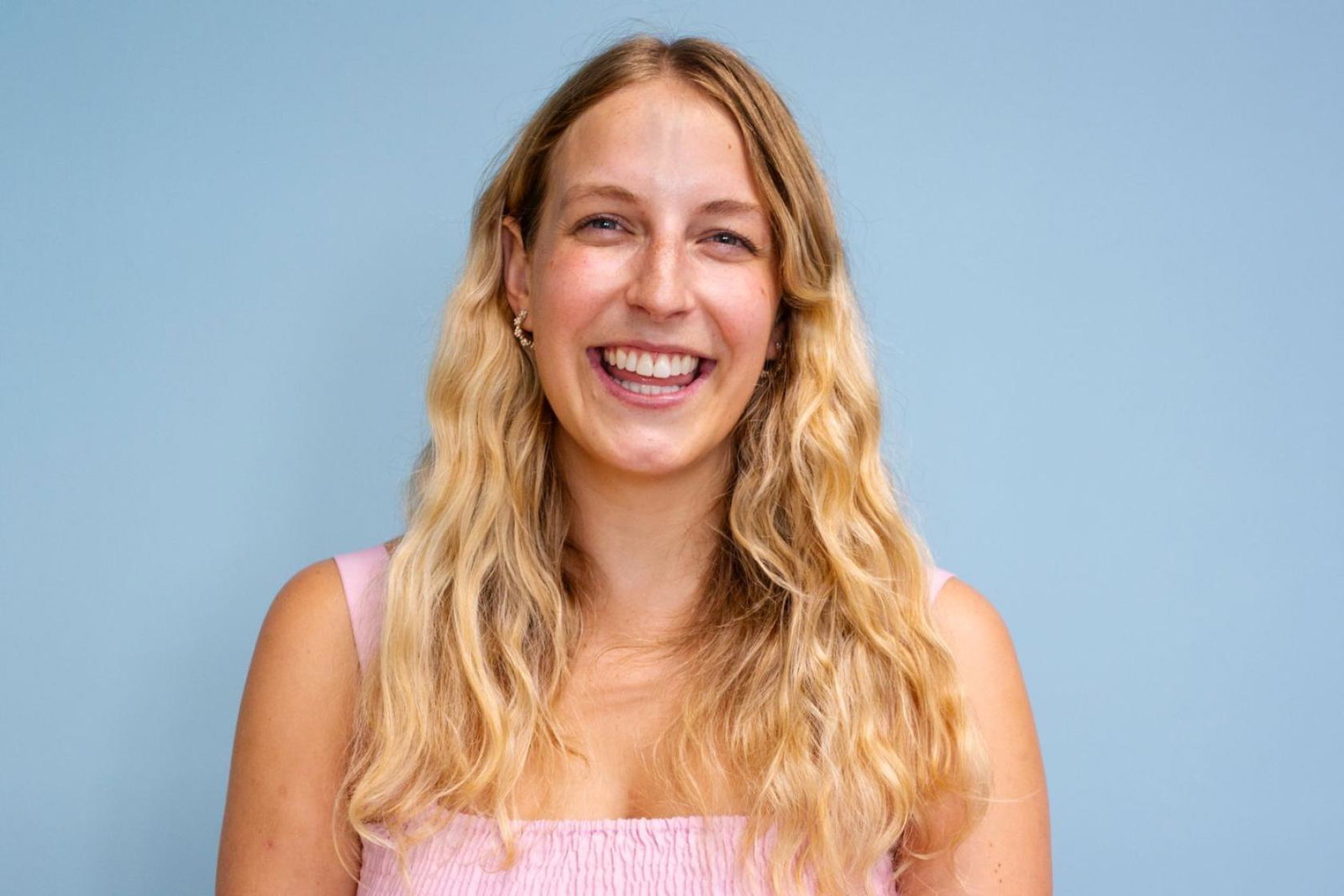 Young white woman with long wavy blonde hair smiling at camera 