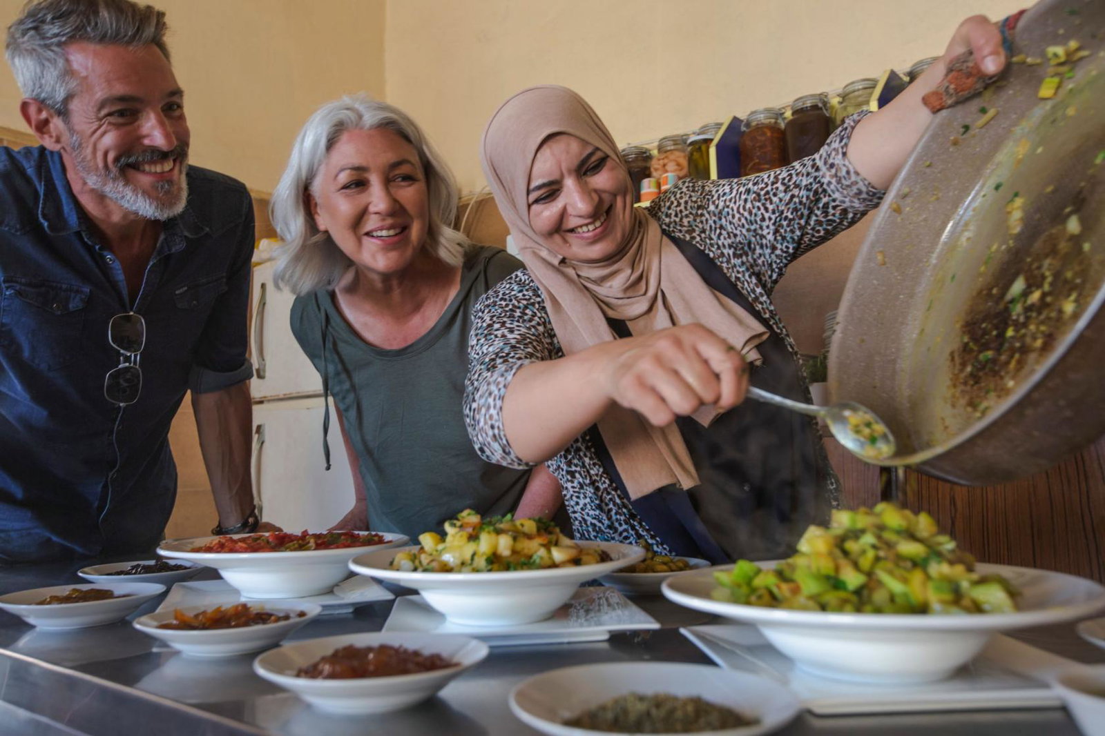 A local host welcomes a tourist couple of a cooking class