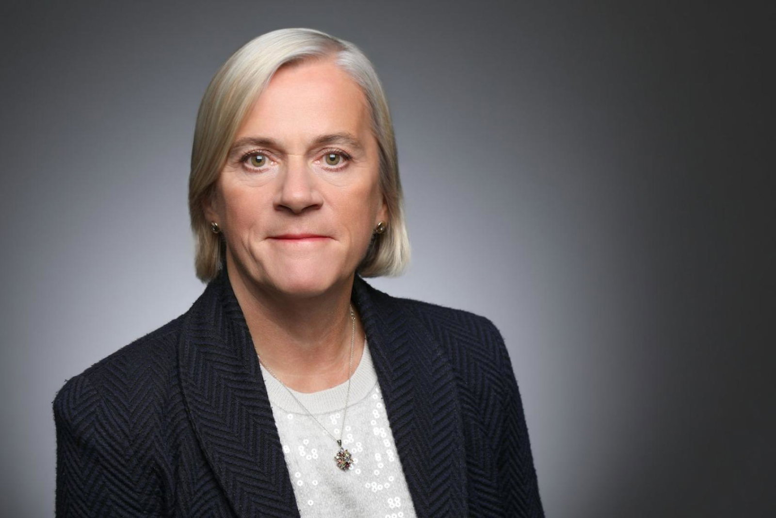 Headshot of middle-aged woman with short blonde hair wearing suit 