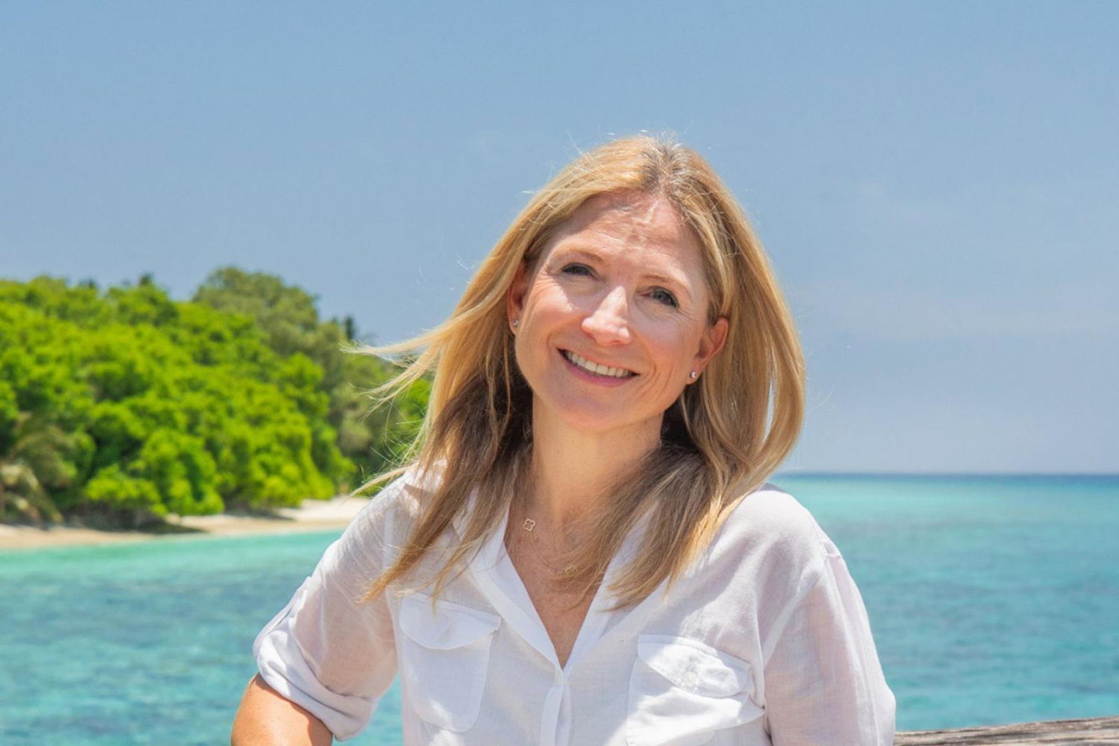 Blonde woman smiling with sea background 