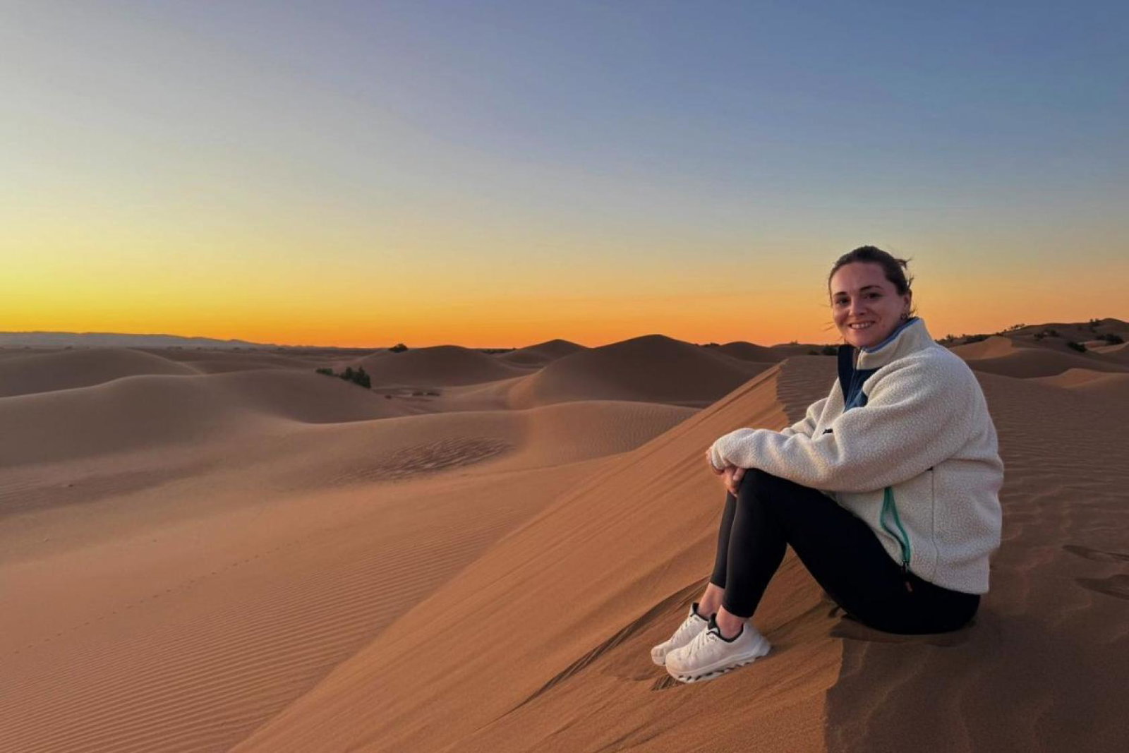 Travel agent Vanessa Good sitting on Sahara sands at sunrise