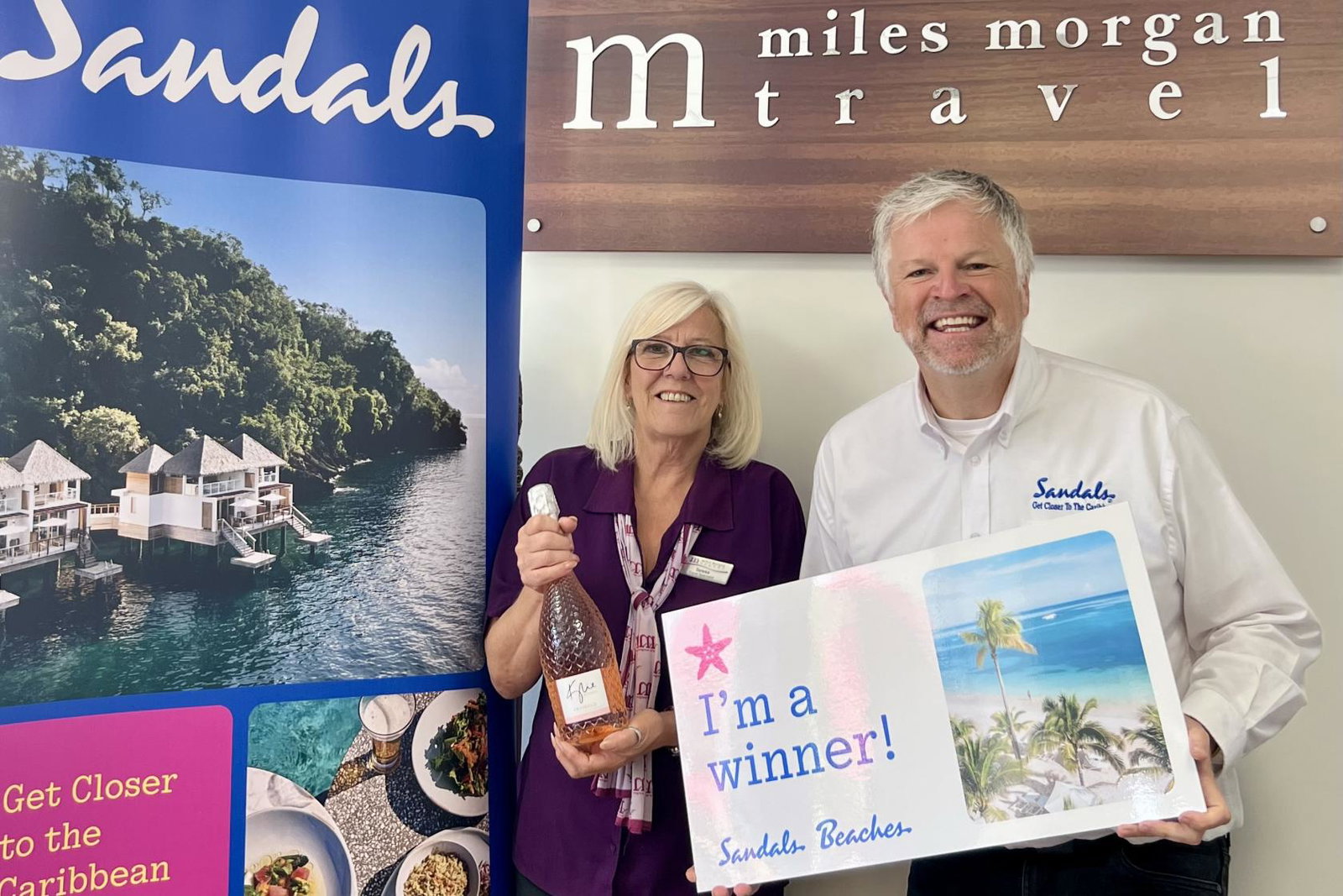 Tersea (left) is pictured with Neil Read (right) holding a gift voucher and a bottle of prosecco. 