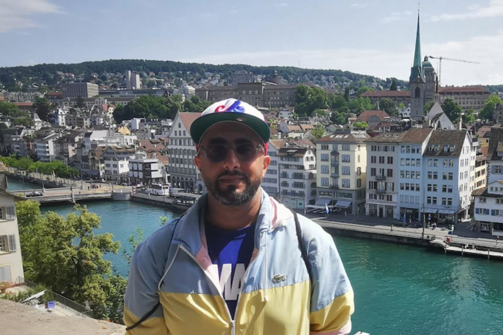 Man with sunglasses and hat in front of river in Europe