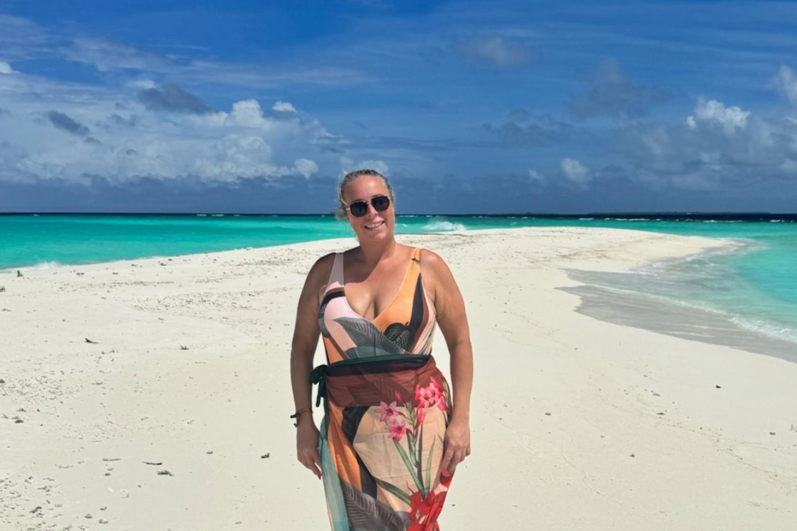 White woman smiling on sandy beach in the Maldives 