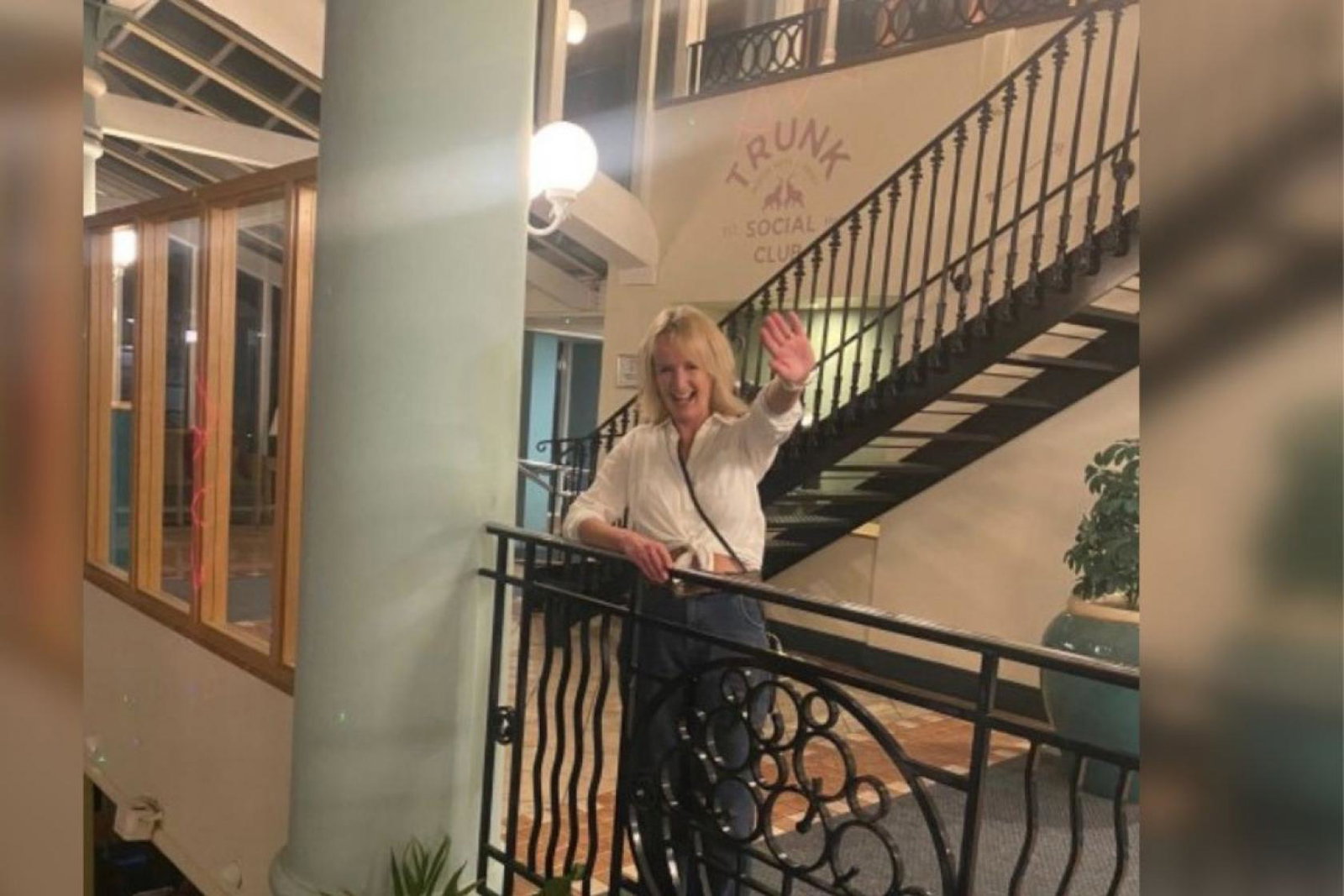 Woman with blonde hair smiling by balcony