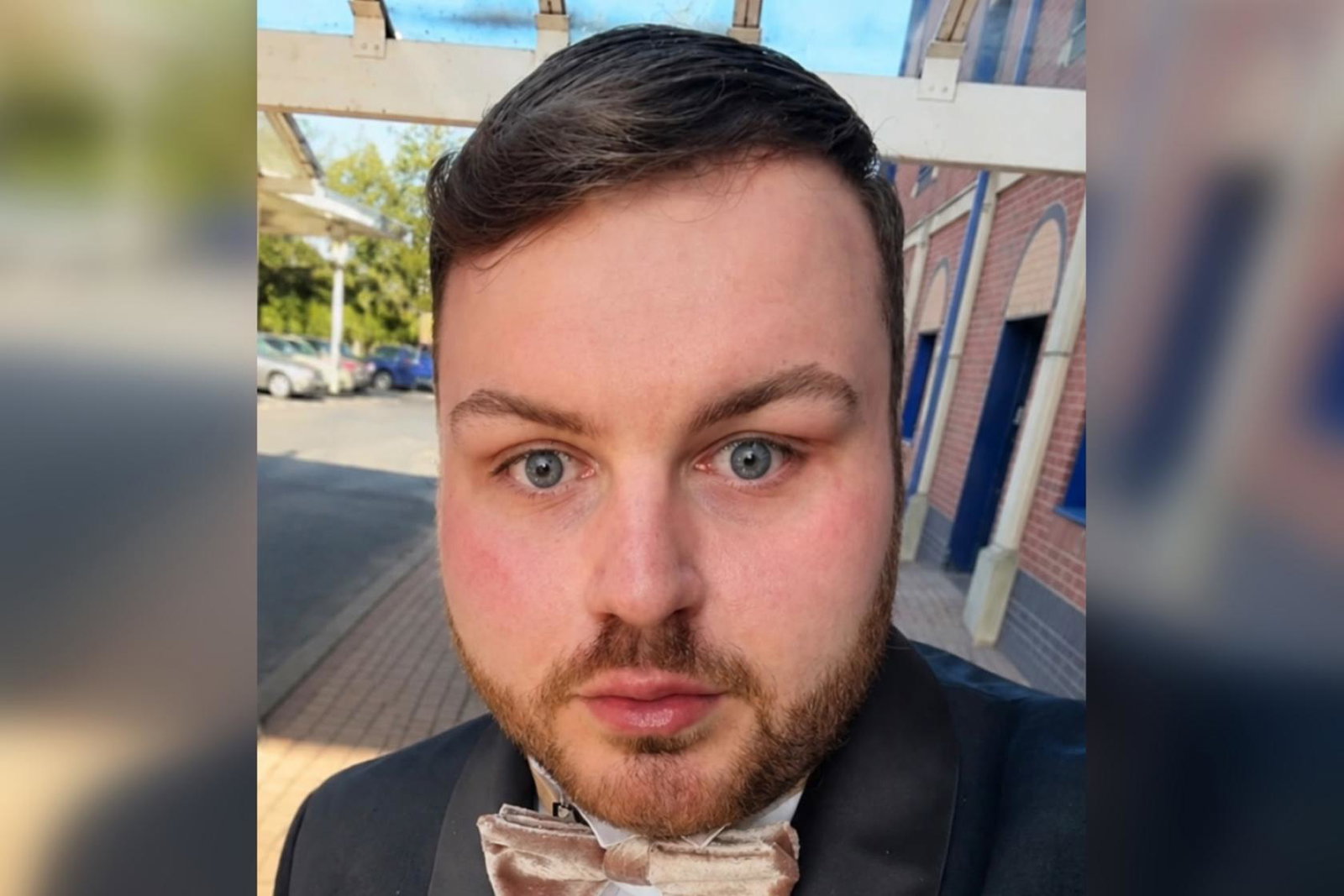 Professional headshot of young white man with short brown hair and tuxedo  