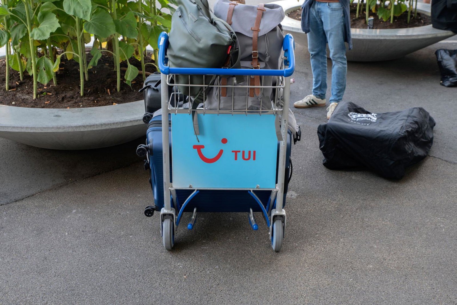 An airport luggage trolley featuring the Tui logo