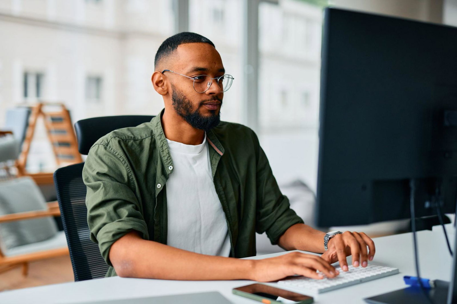 A young professional types at their office workstation