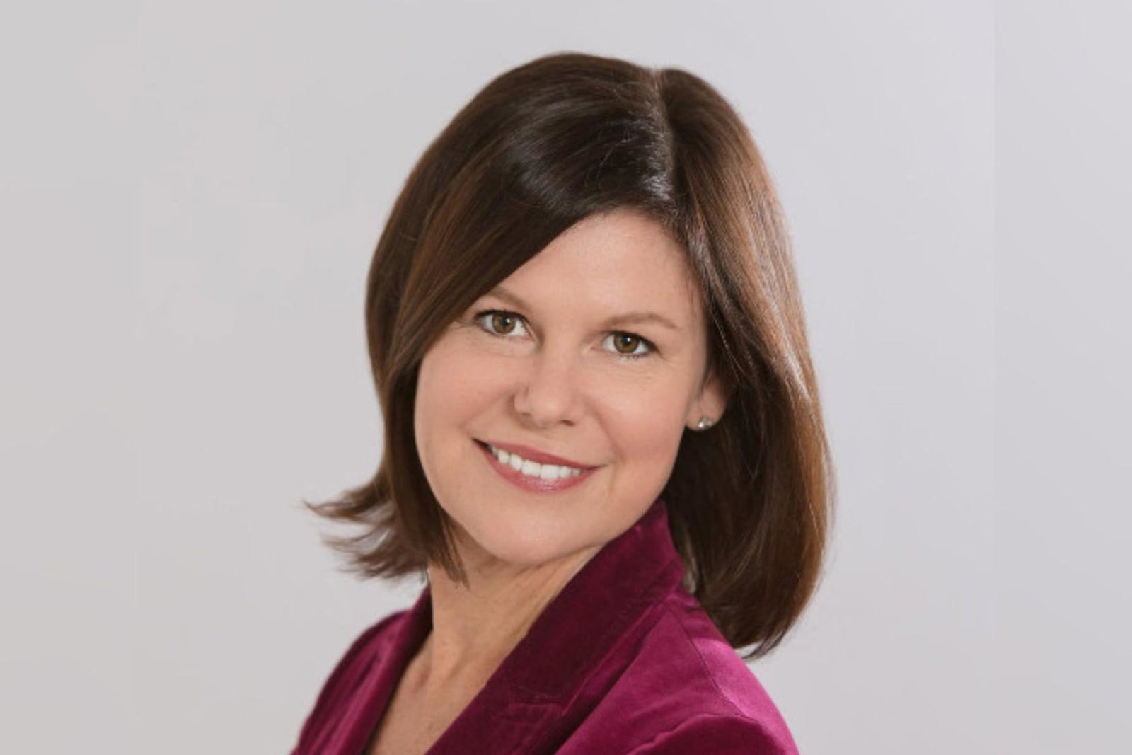 Professional headshot of smiling white woman with brown hair 