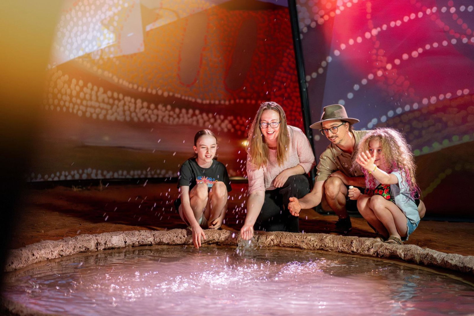 A family enjoy interactive art at Parrtjima festival Alice Springs