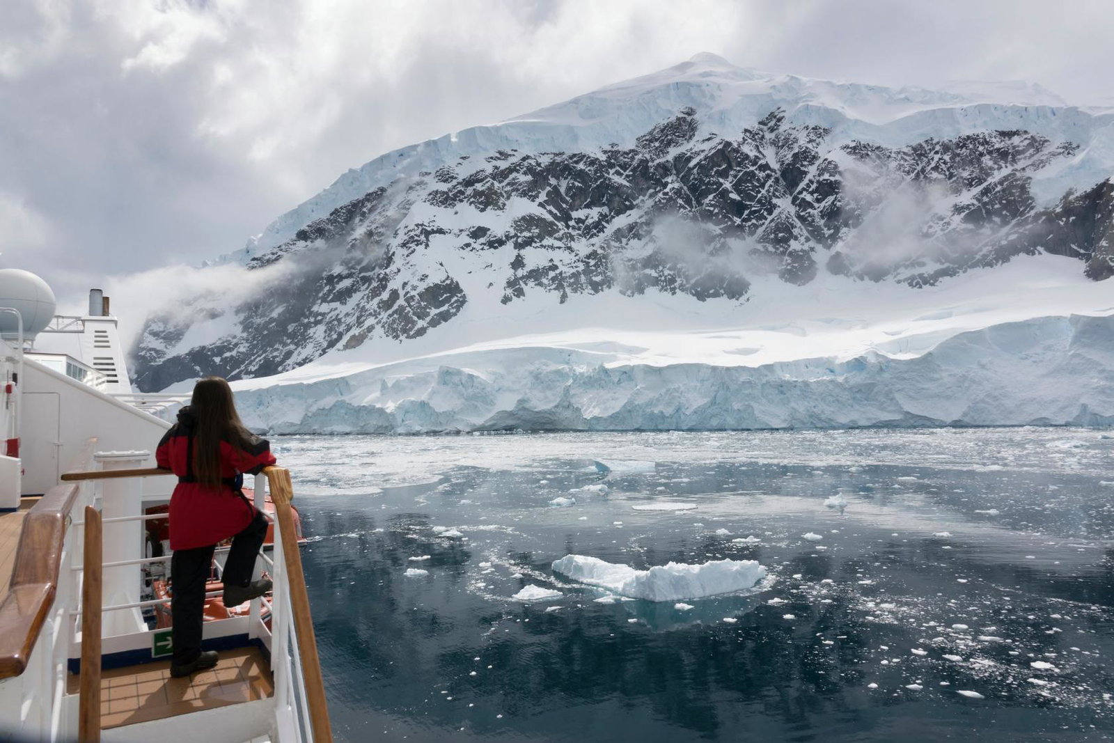 Woman looks at ice shelf during Antartica cruise