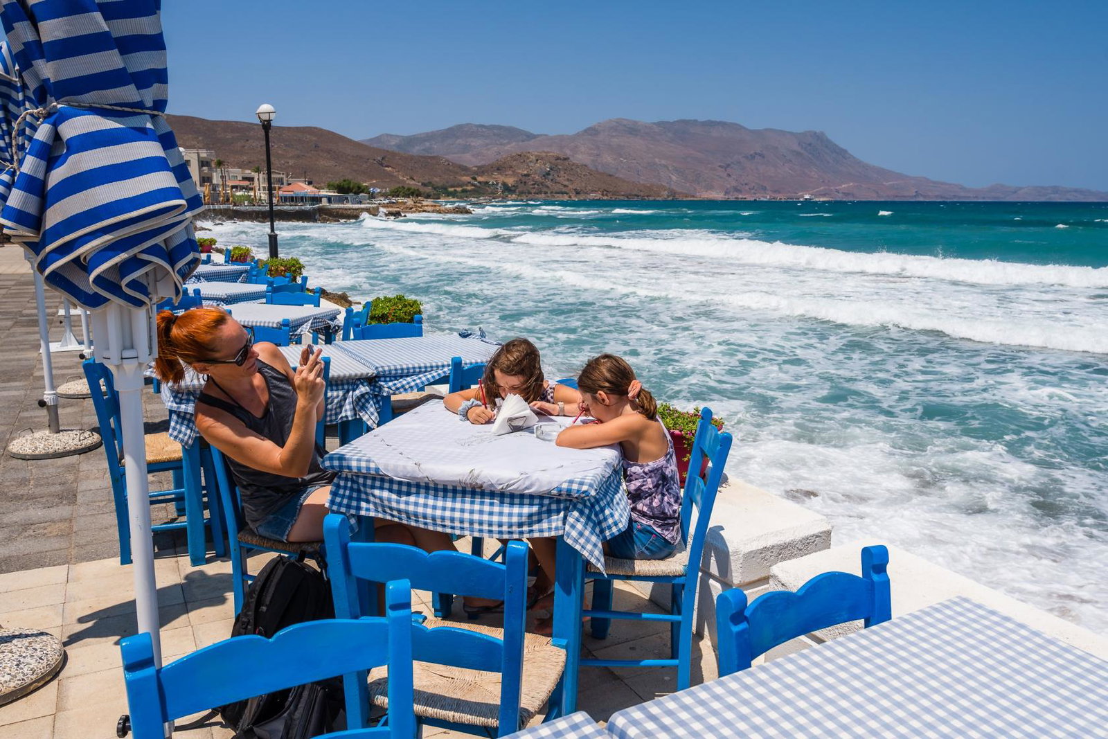 A family sit down at a restaurant by the sea in Kissamos, Crete