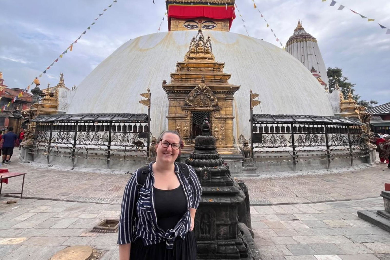 Woman smiling in front of temple in Nepal 