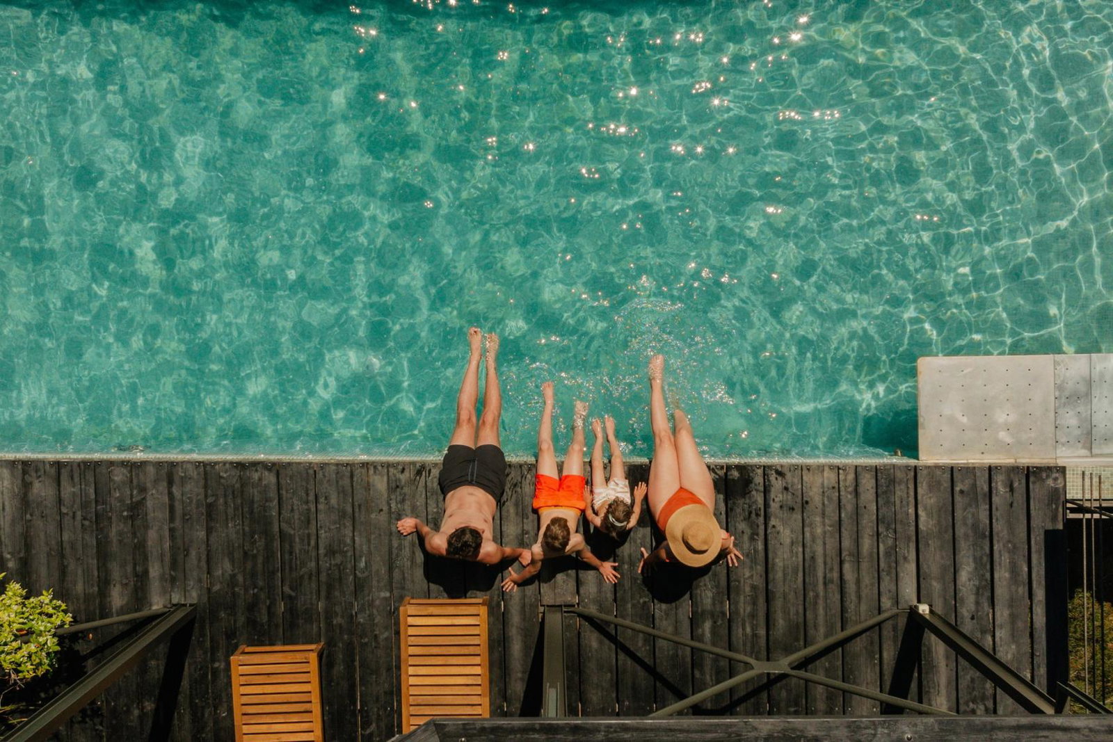 A family relaxing by a pool on holiday