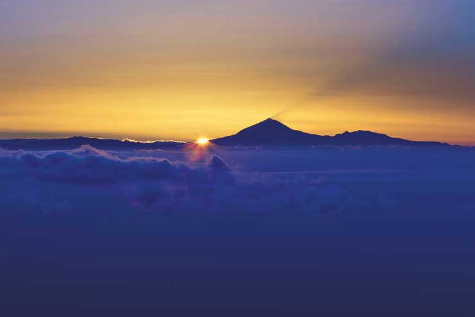 Sunset over mountain and cloud horizon