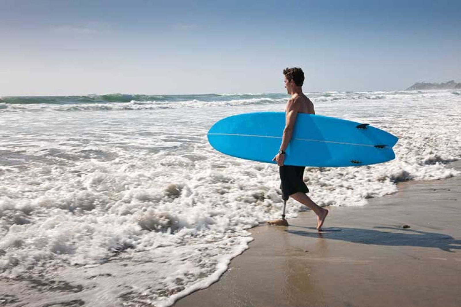 Man with surfboard entering sea