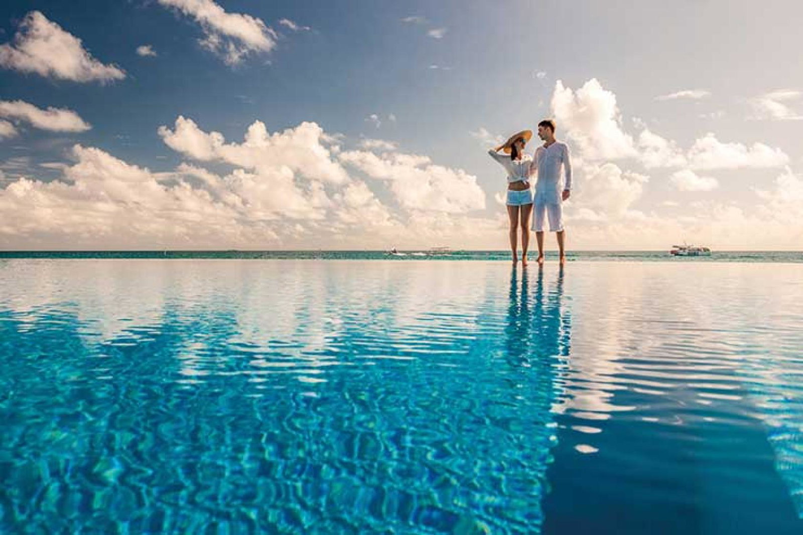 Couple standing by infinity pool