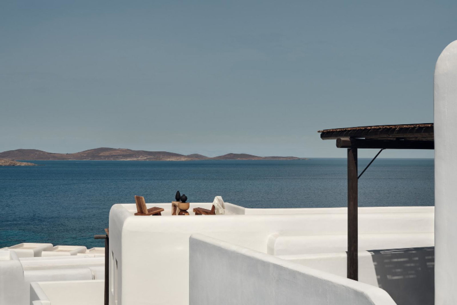Communal areas around the hotel include a swimming pool, wooden pergolas and dining spaces designed for traditional Greek get-togethers