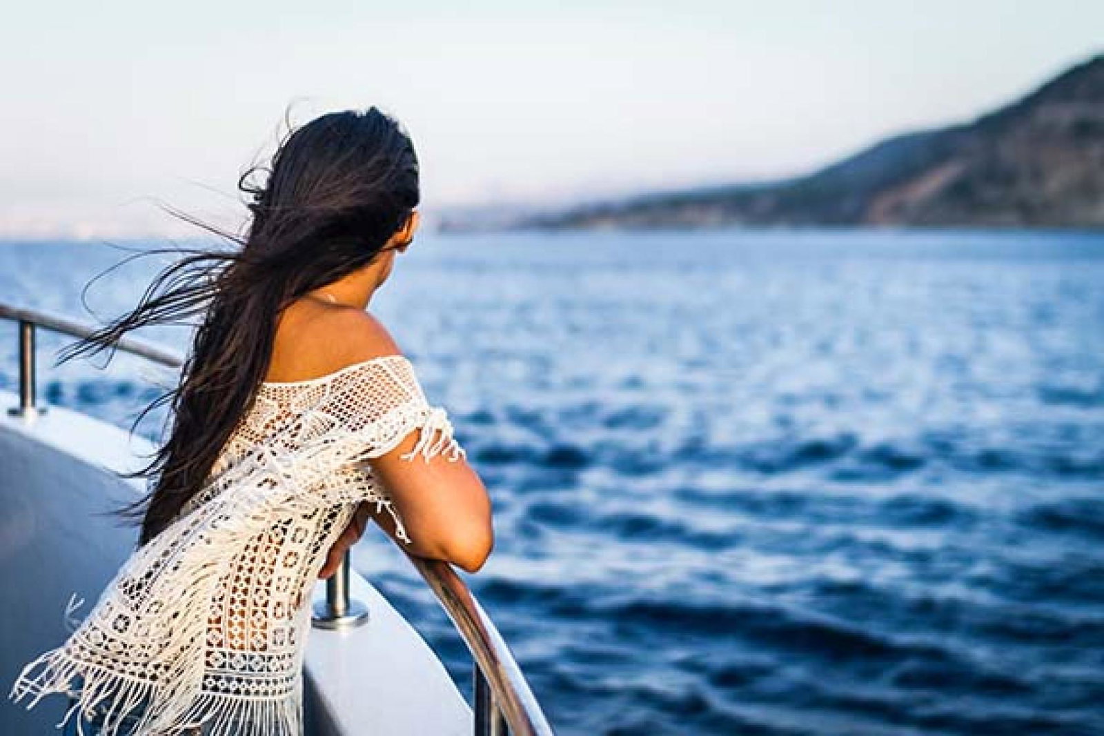 Woman on a cruise ship looking at the seas. 