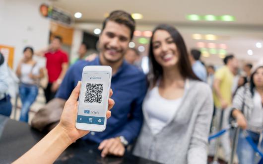 Two people present a QR code to get into an event