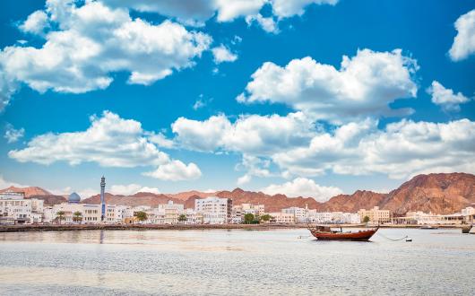 View of Oman coastline with boat in foreground