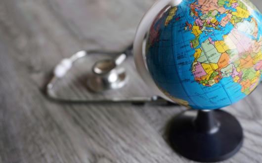 A stethoscope pictured next to a globe