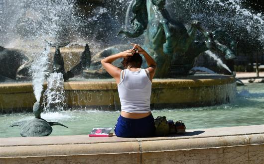 A woman cools off in a Parisian fountain