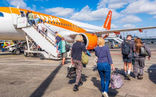 Passengers board an easyJet aircraft