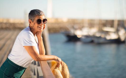 A female solo travellers looks out to sea from a harbour
