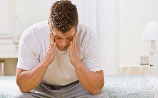 Sick man sitting on a bed