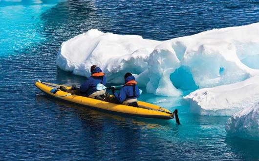 Two men in a canoe among ice floes