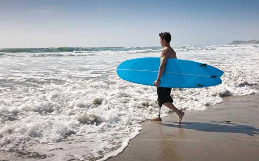 Man with surfboard entering sea