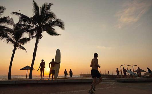 Silhouette of surfers running on the Durban beachfront